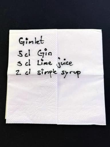 A paper napkin with a handwritten Gimlet spec: 5 cl gin, 3 cl lime juice, 2 cl simple syrup